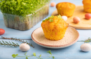 Homemade cakes with chocolate eggs and spinach microgreen on a blue, side view, selective focus.