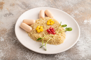 Funny quinoa porridge, and small sausages in form of cat face on brown concrete. side view.