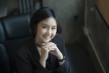 Portrait of a smiling Asian businesswoman looking at the camera.