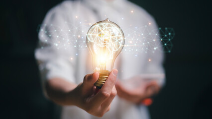 New ideas with innovative technology and creative concepts. Light bulb with a brain inside the hands of the businesswoman. The concept of the business idea.