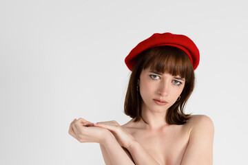 Young beautiful girl only in red tight and a beret, covering her bare chest. Sensual slim girl...