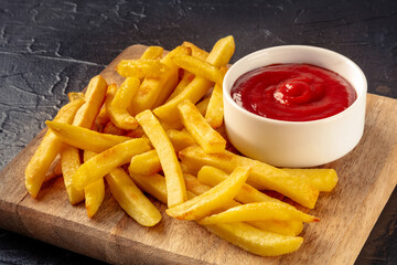 French fries, potato snack with a dip, fast food on a black slate background, a side dish