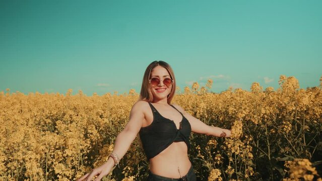 Beautiful sexy young woman on yellow flower meadow in sunset