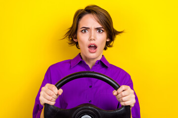 Portrait of impressed crazy person open mouth arms hold wheel staring speechless isolated on yellow color background - obrazy, fototapety, plakaty