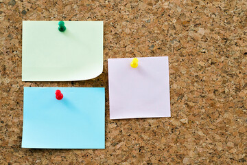 Three notes papers pinned on cork board
