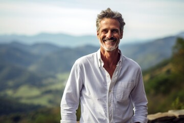 Fototapeta na wymiar Lifestyle portrait photography of a grinning mature man wearing an elegant long-sleeve shirt against a scenic mountain overlook background. With generative AI technology