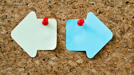 Arrow shape sticky notes on cork board