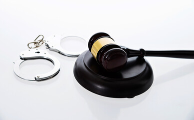 Wooden judge gavel and police handcuffs isolated on white background