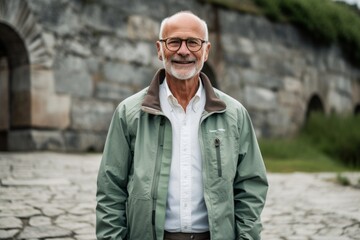 Lifestyle portrait photography of a grinning old man wearing a lightweight windbreaker against a serene rock garden background. With generative AI technology