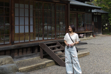 A Japanese woman in jeans and a white shirt outdoors