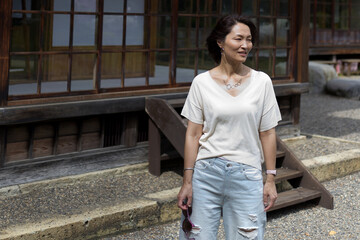 A Japanese woman wearing a white shirt holding sunglasses