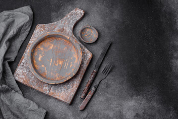 Empty wooden plate, knife, fork and cutting board