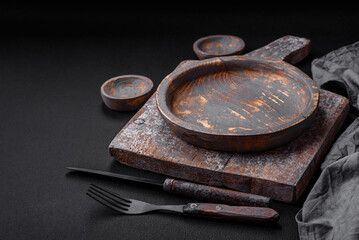 Empty wooden plate, knife, fork and cutting board