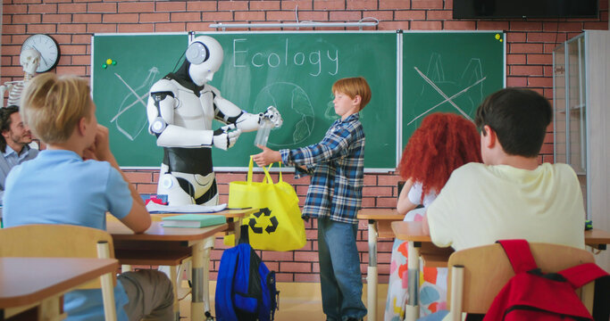 Red haired school boy standing near modern robot at classroom and answering question about ecology. Human like humanoid teaching children to protect nature with recycling waste.