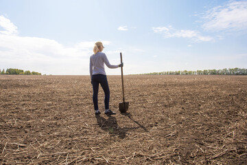 Woman farmer stands on his parched meadow.  farmer at drought field. drought season.