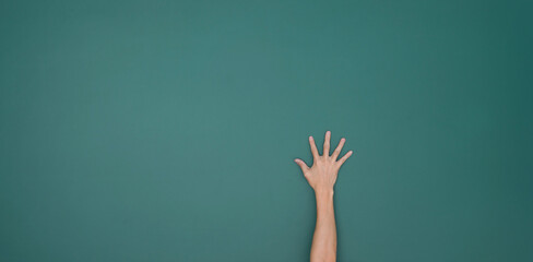 Raised hand in front of chalkboard