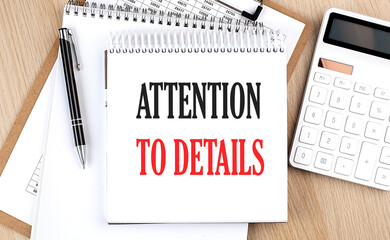 ATTENTION TO DETAILS is written in white notepad near a calculator, clipboard and pen. Business...