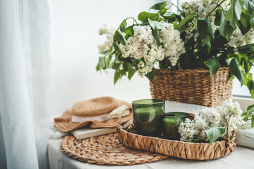 Fototapeta na wymiar Two candles and a basket of white lilacs, aesthetic photo