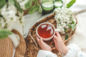 A cup of tea in hands on a background of lilac, top view, aesthetic photo