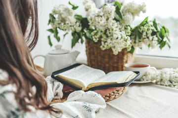 Girl holding an open bible in her hands, home study concept