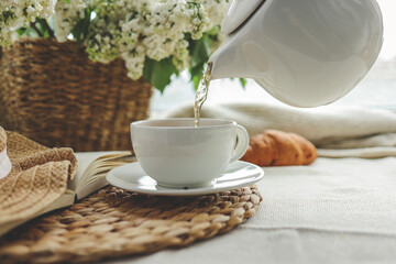 Tea is pouring into a cup from a teapot, beautiful aesthetic photo