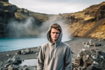 Lifestyle portrait photography of a glad boy in his 30s wearing a stylish hoodie against a scenic hot springs background. With generative AI technology