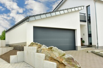 Moderne Beton-Garage mit Automatik-Tor in der Hauszufahrt