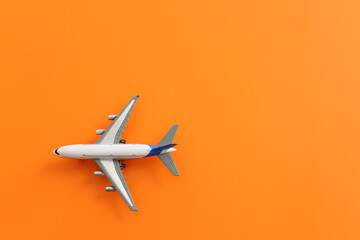 Top view of orange background and airplane. Concept of travel, vacation