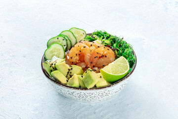 Shrimp poke bowl with avocado, cucumbers, wakame, and lime, a healthy Hawaiian seafood dish with...