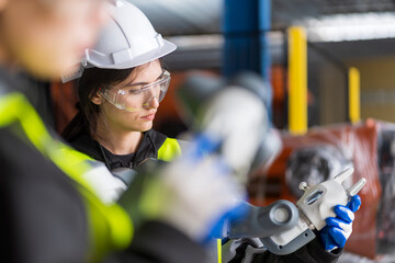 A team of female engineers meeting to inspect computer-controlled steel welding robots. Plan for rehearsals and installation for use.