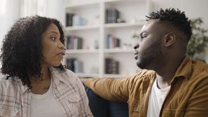 Fototapeta premium Beautiful African American couple having conversation at home, showing love and appreciation