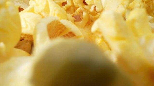 A captivating macro shot with a probe lens, scattered popcorn on the floor comes to life. Each popped kernel showcases intricate textures, revealing the golden hue, crispy edges, and tiny crevices.
