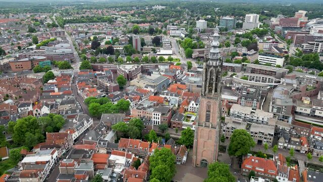 This aerial drone video shows the Lieve Vrouwentoren, a large clock tower in the old city center of Amersfoort. Amersfoort is a beautiful city in Utrecht, the Netherlands.