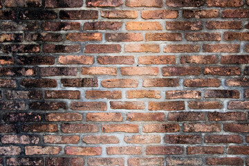 Grunge old and crack red color brick with black stain wall textured background.