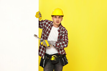 professional builder in work clothes in helmet holding hammer.