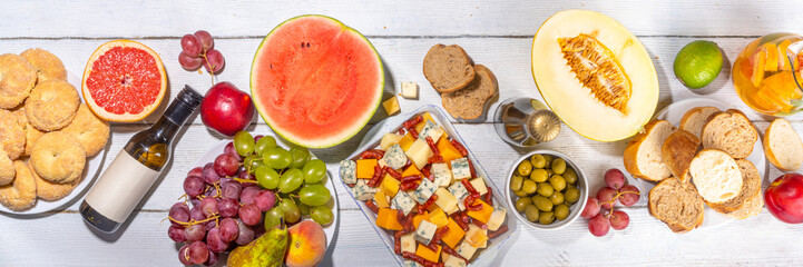 Buon Ferragosto (happy in italian language) holiday background. Summer Italian harvest festival August 15  brunch, family party antipasto foods with watermelon, melon, grapes, cheese, snacks, drinks