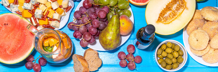 Buon Ferragosto (happy in italian language) holiday background. Summer Italian harvest festival August 15  brunch, family party antipasto foods with watermelon, melon, grapes, cheese, snacks, drinks