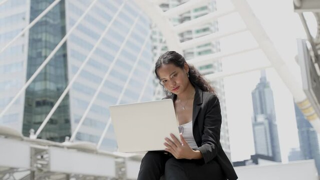 Portrait of young asian businesswoman working on laptop