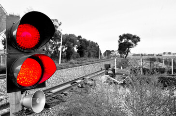 Traffic light shows red signal next to railway lines