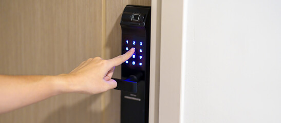 Hand press PIN number for smart digital door lock while open or close the door at home or apartment. NFC Technology, Fingerprint scan, keycard, smartphone and contactless lifestyle concepts