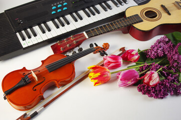 Fototapeta premium Guitar, violin, synthesizer and a bouquet of tulips and lilacs.