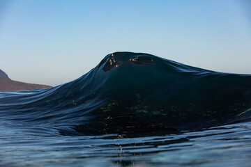 dark and moody wave breaking on a reef