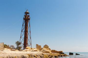 Fototapeta na wymiar An old eifell lighthouse with a red roof on the seashore Jarylgach island