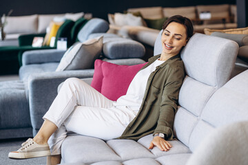 Woman sitting on a new sofa in a furnire store