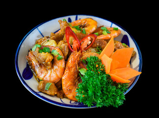 Salt fried shrimp with sauce and vegetables isolated on black backround
