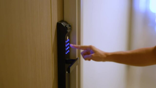 Hand press PIN number for smart digital door lock while open or close the door at home or apartment. NFC Technology, Fingerprint scan, keycard, smartphone and contactless lifestyle concepts