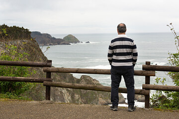 Hombre viendo el paisaje de un acantilado en Asturias, España.