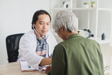 Asian doctor use stethoscope listening lung of patient, elderly health check up.