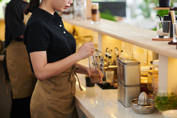 Coffeeshop barista making cold drink for customer