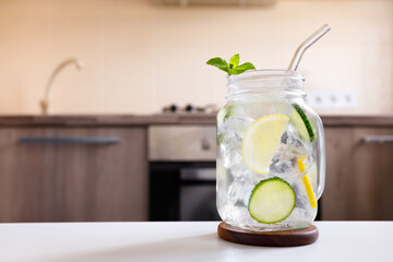 mason jar of cold homemade lemonade with kitchen as background